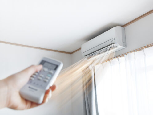A person turning on the mini-split in their home